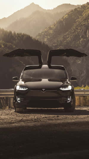 黑色Tesla Model X在山路上打開車門，日落時分。