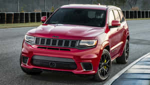 賽道上的紅色Jeep Grand Cherokee Trackhawk，黑色車輪和黃色制動卡鉗。