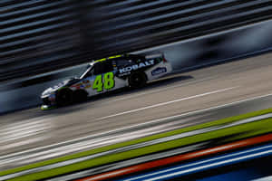 NASCAR賽車48號在賽道上高速行駛，帶有動態模糊。