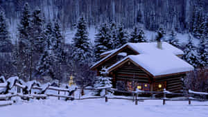 夜晚雪地森林中舒適的小屋，溫暖的燈光閃爍。 — 冬日美學 壁紙