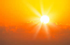 夕陽天空，帶有發光的太陽和橙色雲彩