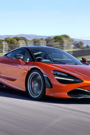 橙色McLaren 720S在道路上疾馳，背景模糊，天空清澈。