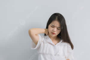 年輕女性不適地按著脖子，表情痛苦。