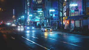 霓虹燈照亮城市街道的夜雨，汽車駛過水坑。