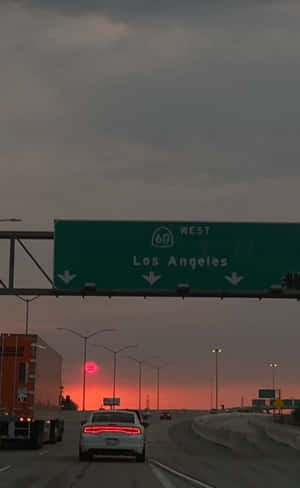 日落時分，高速公路上的車輛向西駛向洛杉磯，天空呈現橙色。
