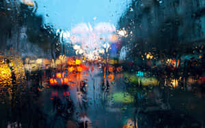 雨點斑駁的窗戶，顯示夜間模糊的城市燈光。