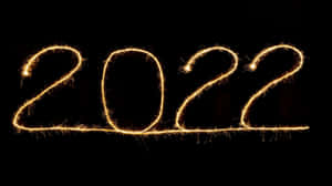 金色煙火在黑色背景上寫出2022年。
