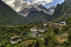 一個位於山谷中的小村莊，周圍環繞著綠色森林和白雪覆蓋的山峰。