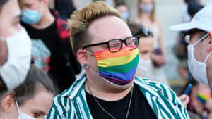 喺Pride活動中戴住彩虹口罩同眼鏡嘅人，周圍係戴口罩嘅人群。