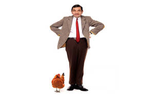 Mr. Bean 身穿西裝，站在白色背景的雞旁邊。 — 雞丁 GIF 壁紙