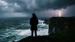 人站在懸崖上觀看閃電劃過波濤洶湧的海面。 — 抑鬱 GIF 壁紙