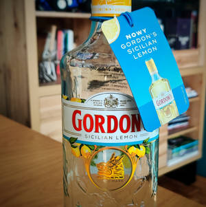 Gordon's Sicilian Lemon氈酒瓶，帶藍色標籤，放在木桌上。