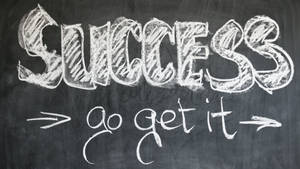 黑板上用粉筆寫著 success go get it 的勵志文字