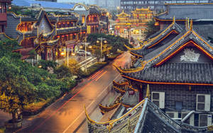 夜晚的傳統中國建築，濕漉漉的街道和車燈軌跡。 — 唐人街 GIF 壁紙