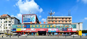繁忙的城市電子市場，在藍天下有彩色招牌和建築物。