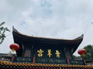 多雲天空下的中式寺廟，有紅色燈籠和金色字體