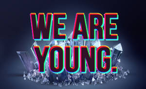 在深色背景上，從水晶碎片中升起的霓虹發光文字 WE ARE YOUNG。