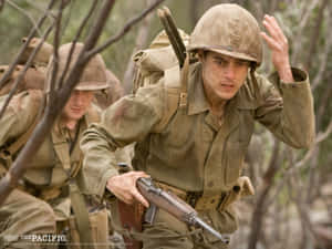 身穿卡其色軍服和頭盔的士兵手持步槍穿過森林。