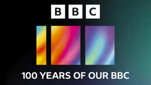 BBC 100 週年標誌，帶有彩色漸變條，背景為深藍綠色。