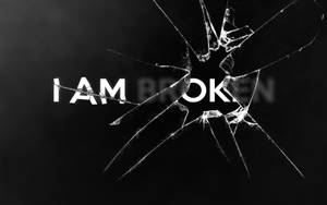 黑色背景上帶有粗體文字 'I AM BROKEN' 的碎裂玻璃覆蓋層。