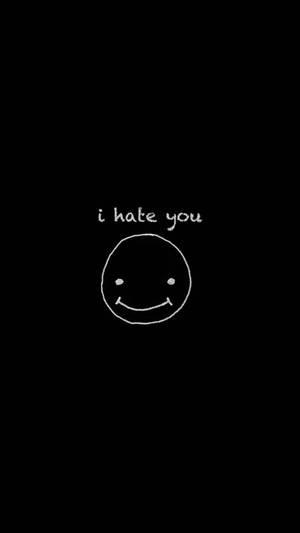 在黑色背景上，用白色粉筆畫出一個笑臉，上方有 i hate you 字樣。