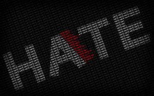 「hate」呢個字嘅文字圖案喺黑色背景上形成一個紅色心形。