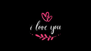 粉紅色心形和葉狀裝飾圍繞著黑色背景上的白色草書 i love you 字句。
