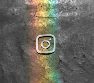 裂開混凝土上的白色黏土Instagram標誌，帶有彩虹光反射。