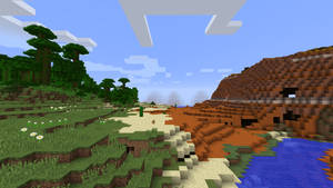 藍天下有樹木、河流和山脈的Minecraft景觀