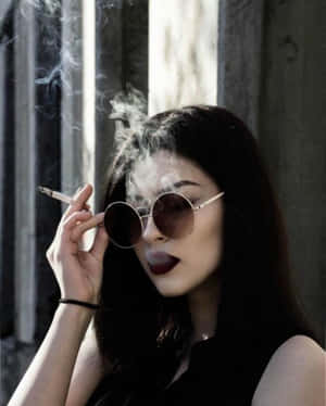戴太陽眼鏡的女性在窗邊陽光下抽煙。