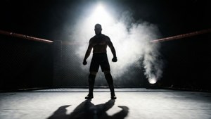 一位肌肉發達的戰士站在黑暗的MMA籠子裡，聚光燈下煙霧繚繞。