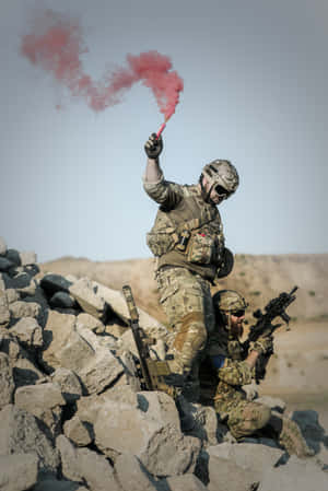 兩名身穿戰鬥裝備的士兵在岩石地形上，其中一人手持紅色煙霧信號彈。 — Huawei MatePad 11.5 S (2025) 壁紙