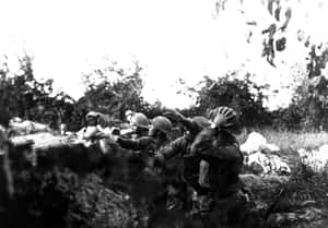 戴頭盔的士兵在一張黑白戰爭照片中蹲在戰壕後方。 — 戰爭 壁紙