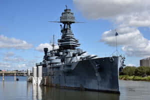 灰色戰艦停泊在水中，背景為多雲天空 — 現代戰爭 壁紙