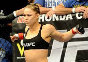身穿黑色UFC裝備的女性MMA拳手站在八角籠中準備戰鬥。