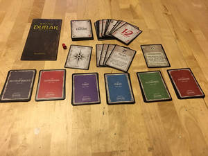 Battle Durak 卡牌遊戲在木地板上設置，附有規則書和角色卡。