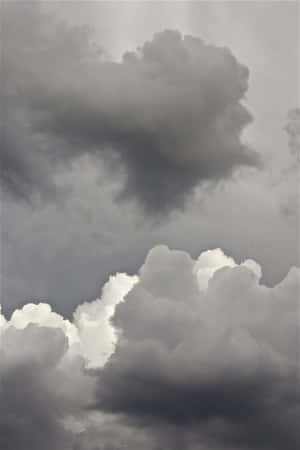 暴風雨天空中戲劇性的灰色和白色雲層。 — 純灰色 壁紙