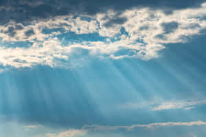 陽光穿過散落的雲層，照耀在充滿活力的藍天上。 — 藍天 壁紙