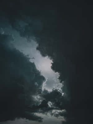 黑暗的暴風雲散開，露出上方明亮的發光天空。 — iPad Air 壁紙