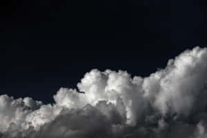 戲劇性的雲朵在黑暗夜空下被照亮 — MacBook 壁紙