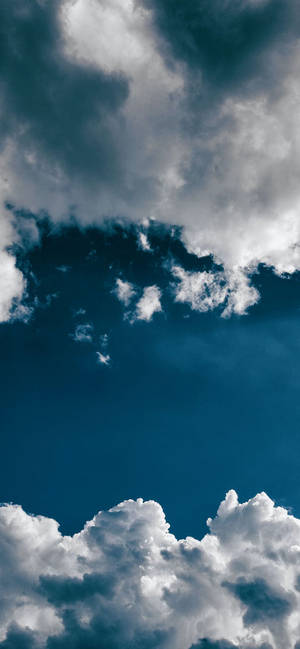 戲劇性的白雲在深藍色天空中。 — iPhone 17 Pro Max 壁紙