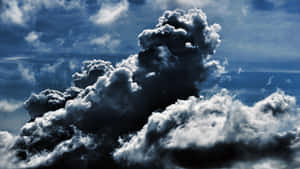 密集的深色暴風雲，帶有亮白色邊緣，映襯著深藍色的天空。 — 暗色 壁紙