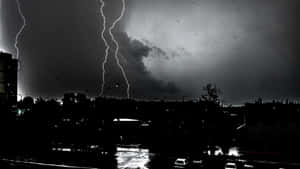 在一個雨夜，閃電劃過黑暗的城市景觀。 — 暴風 壁紙
