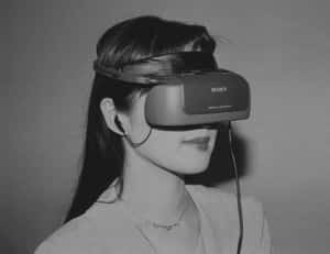 女性戴著復古Sony VR頭戴式裝置和耳機的黑白照片。