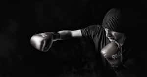 戴冷帽的拳擊手在煙霧瀰漫的昏暗工作室中揮拳 — 拳擊 壁紙
