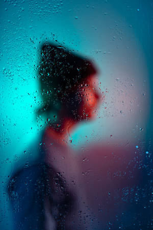 透過雨窗看到的人影，帶有藍色和紅色燈光。 — 霓虹美學 壁紙