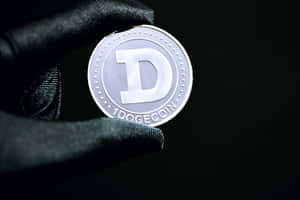 戴手套的手在黑色背景上托著一枚銀色Dogecoin。 — MacBook Pro M3 壁紙