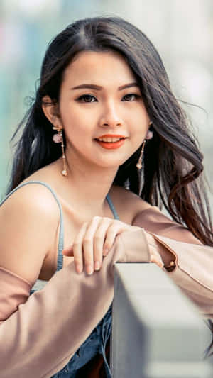 年輕女性微笑著靠在戶外欄杆上