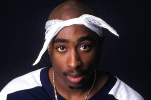 Tupac Shakur 喺攝影棚肖像中戴住白色頭巾同金鏈。