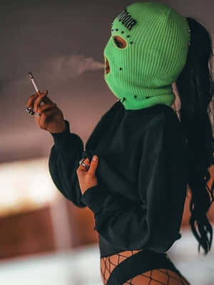 戴綠色巴拉克拉法帽的人吸煙，穿著黑色連帽衫和漁網襪。